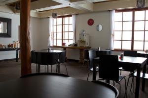 Un comedor con mesas y sillas y ventanas. en Hakuba House, en Hakuba 11 fotos más