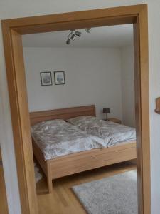 a bedroom with a bed and a mirror at Ferienwohnung Doblhofer in Untergriesbach