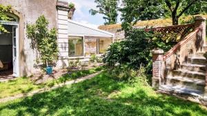 an old brick house with a yard with grass at La Houache Chambres d'Hôtes in Le Pellerin