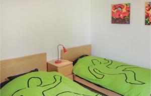 a bedroom with two beds with green covers and a lamp at Gorgeous Home In Bédarieux in Bédarieux