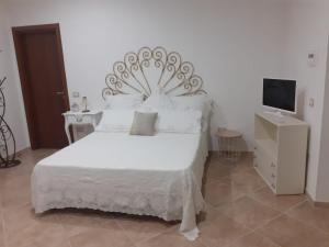 sypialnia z białym łóżkiem i telewizorem w obiekcie B&B San Paolo w mieście Campagna
