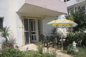 a patio with an umbrella and a table and chairs at Lenny in Kranevo