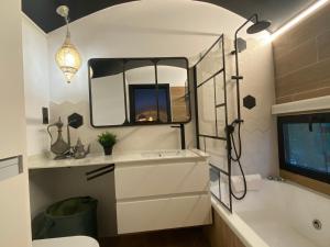 a bathroom with a tub and a sink and a mirror at Vagón Orient Express in Casas Altas