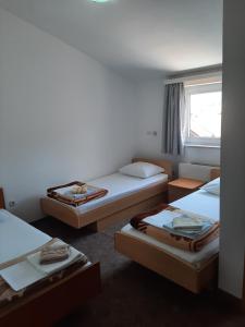 une chambre avec trois lits et une fenêtre dans l'établissement Anđela, à Međugorje