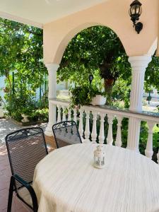 - une table et des chaises blanches sur une terrasse couverte dans l'établissement Villa Chiara, à Vodice
