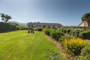 a house with a large lawn in front of it at Beenoskee Bed and Breakfast in Castlegregory