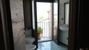 a bathroom with a toilet and a sink and a balcony at B&b La Margherita in Pietrapertosa