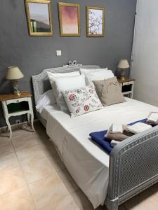 a large white bed with pillows on it in a bedroom at La caseta Domaine du CANTEAU YF in Panjas