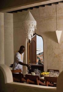 a man standing in front of a table in a restaurant at Samaki House in Lamu