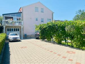 ein Haus mit zwei Autos, die vor einer Einfahrt geparkt sind in der Unterkunft Villa Chiara in Vodice