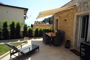 een patio met een tafel en stoelen en een parasol bij la casa di Gaia in Taormina
