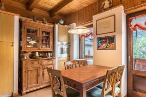 cocina y comedor con mesa de madera y sillas en Appartamento Albachiara 2, en Ossana