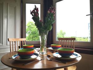 a wooden table with a vase of flowers on it at Forth View Apartment in Stirling