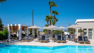 a swimming pool with lounge chairs and umbrellas at Dedalos Hotel in Malia