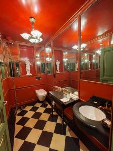 La salle de bains rouge est pourvue d'un lavabo et de toilettes. dans l'établissement Hôtel du Vieux Marais, à Paris