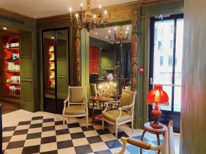 a dining room with a table and chairs and a chandelier at Hôtel du Vieux Marais in Paris