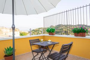 a table and chairs on a balcony with an umbrella at La Dimora Di Segesta B&B in Calatafimi