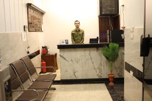 un hombre parado detrás de un mostrador en una barbería en Royal hotel Tanta - فندق رويال طنطا, en Tanta