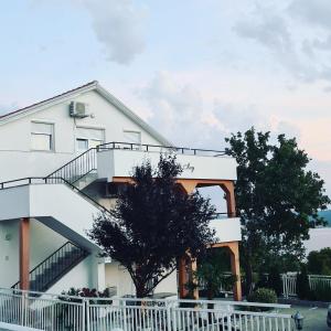 a white house with a staircase in front of it at Apartments Lujić in Crikvenica