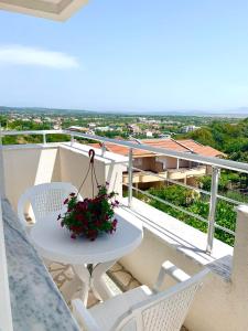a white table and chairs on a balcony with flowers at Apartments Hillside in Ulcinj
