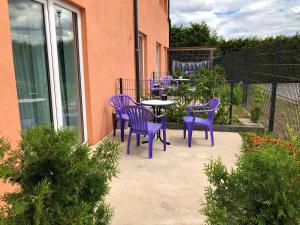 - un ensemble de chaises violettes et une table sur une terrasse dans l'établissement Pension Lara, à Magdebourg