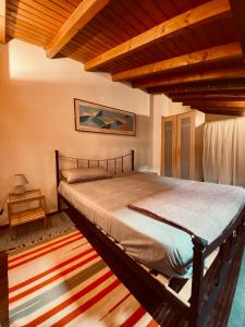 a bedroom with a bed in a room with wooden ceilings at Casa al Vittoriale degli Italiani di Gabriele D' Annunzio - Casa Vacanze in Gardone Riviera