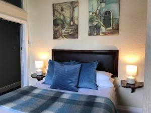 a bedroom with a bed with blue pillows and two lamps at The Exhibition in York