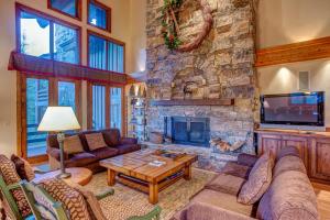 a living room with a large stone fireplace at La Maconnerie #15 in Park City