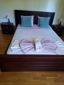 a large bed with pink sheets and pillows on it at K's Place Apartment Pravets Golf Resort in Pravets