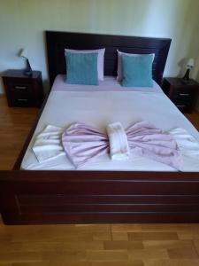un grande letto con lenzuola e cuscini rosa di K's Place Apartment Pravets Golf Resort a Pravets