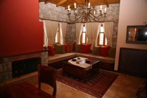 a living room with a couch and a fireplace at Roes Suites in Kato Loutraki