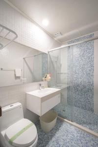a bathroom with a toilet and a sink and a shower at 日軸蒔光 in Hualien City