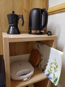 a coffee pot and a toilet on a wooden shelf at Młyn Hipolit glamping in Nowy Gaj