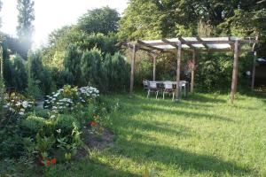 a garden with a table and a wooden pergola at Trappenkamper Hof, Hunde gerne auf Anfrage in Tarbek