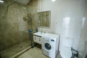 a bathroom with a washing machine and a shower at West Apart Hotel in Batumi