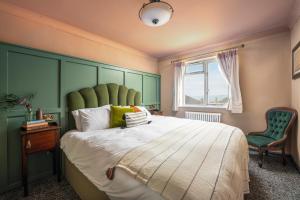 a bedroom with a large bed with a green headboard at Hope & Anchor in Hope Cove