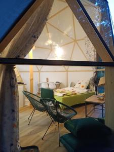 a room with a tent with a couch and chairs at Młyn Hipolit glamping in Nowy Gaj
