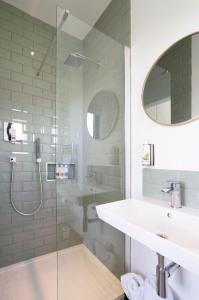 uma casa de banho com um lavatório e uma cabina de duche em vidro. em Box6 at West Down em Sherborne