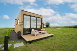 a tiny house with a table and chairs in a field at Box6 at West Down in Sherborne