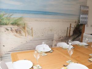 a table with wine glasses and a view of the beach at 4 Roman Bank in Mablethorpe