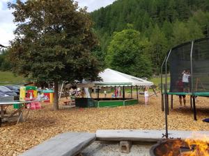 a park with a tent and a playground with a tree at Alpin Appart Reiterhof in Niederthai