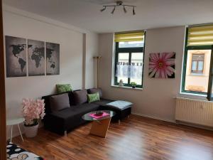 a living room with a black couch and a table at Ferienwohnung Eddi in Reichenbach im Vogtland