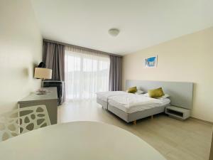 a bedroom with a bed and a large window at Apartamenty Czarna Góra Veraneo in Sienna