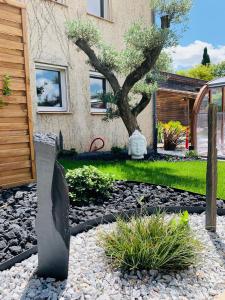 un jardín con un árbol frente a una casa en Hôtel Restaurant Le Clos Fleuri, en Castelnaudary