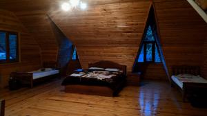 a bedroom with a bed in a log cabin at Hotel Texel in Borjomi