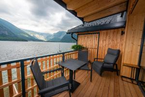 einen Balkon mit Stühlen und einem Tisch auf einem Boot in der Unterkunft Boutiquehotel Strand Hallstatt - Adults only in Hallstatt