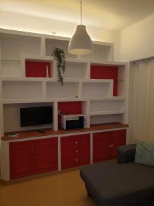 een woonkamer met rode kasten en een flatscreen-tv bij Riverside Triana in Sevilla