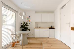 uma cozinha com armários brancos e uma mesa branca em Sweet Suite - Zentrale Wohnung nähe Augarten em Viena