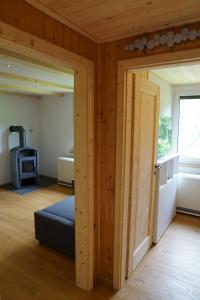 a room with a door open to a room with a stove at Ruhiges Ferienhaus am Waldrand mit Sauna und Kamin in Langenbach