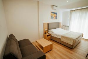 sypialnia z łóżkiem i kanapą w obiekcie West Apart Hotel w mieście Batumi